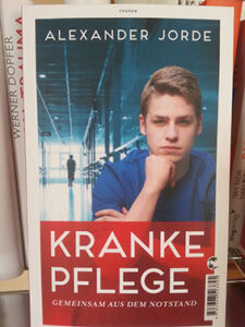"Kranke Pflege: Gemeinsam aus dem Pflegenotstand" vor dem Bücherregal